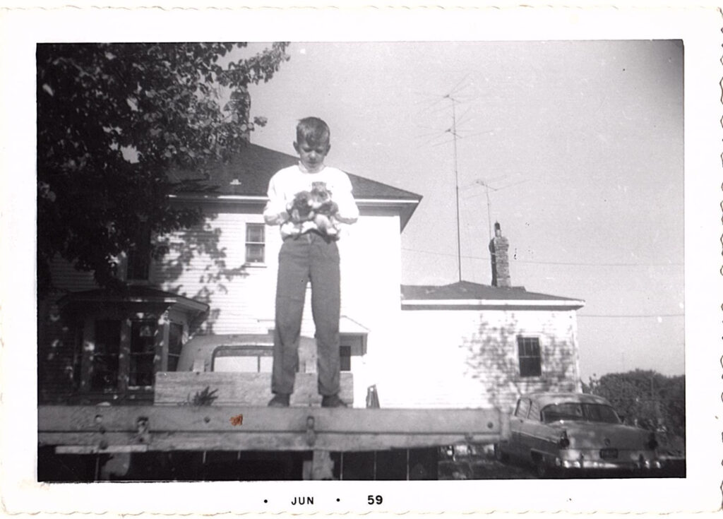 Boy standing on wooden platform outdoors.