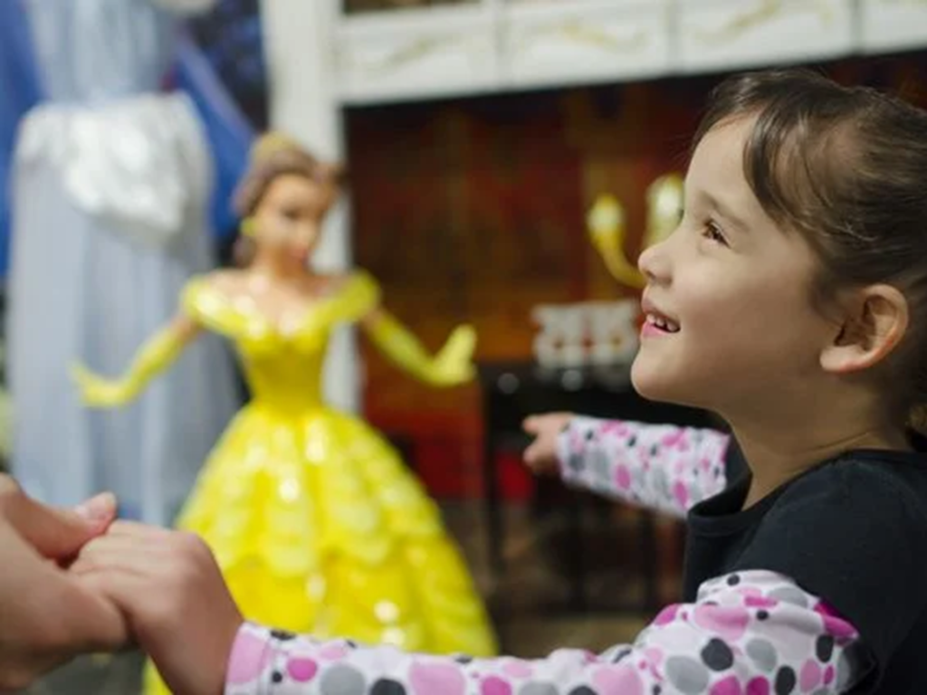 Child pointing at yellow princess figure