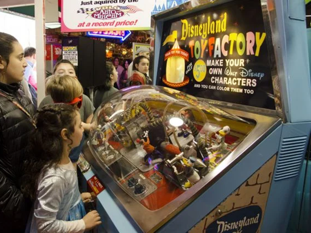 Children interacting with toy factory machine.