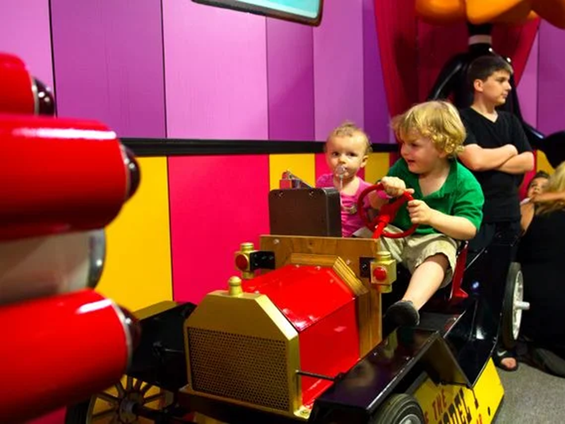 Children playing in a toy car.