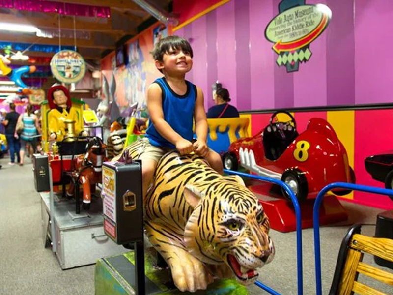 Child riding a tiger statue.