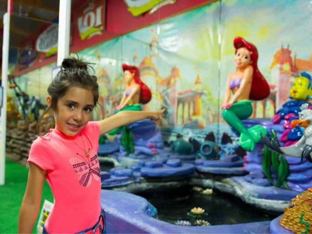 Child pointing at mermaid statue.
