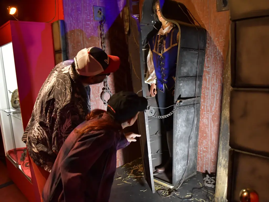 Two people observing a coffin display.