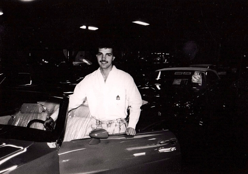 Person standing by a classic car.