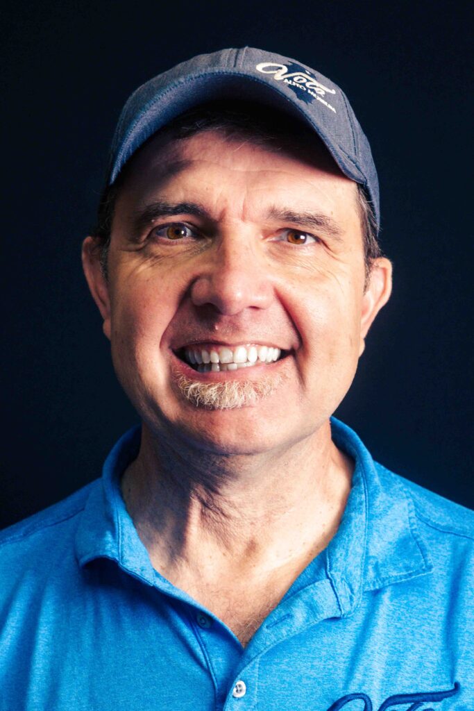 Man in blue shirt and cap.