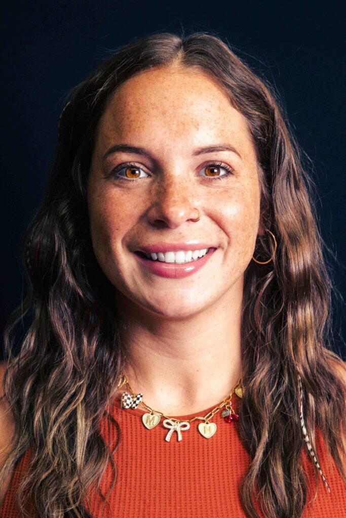 Woman with wavy hair and necklace.