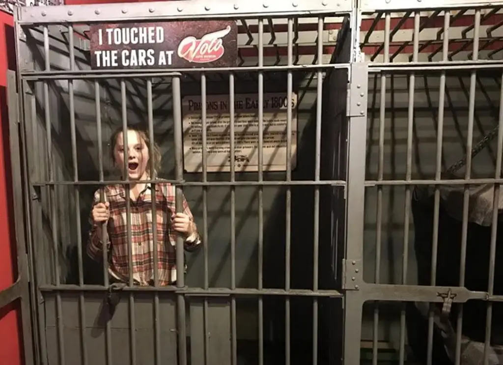 Person in jail cell exhibit.