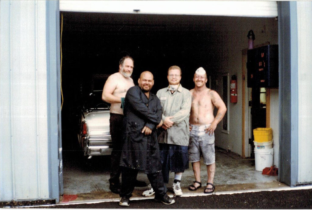 Group of people in garage setting.
