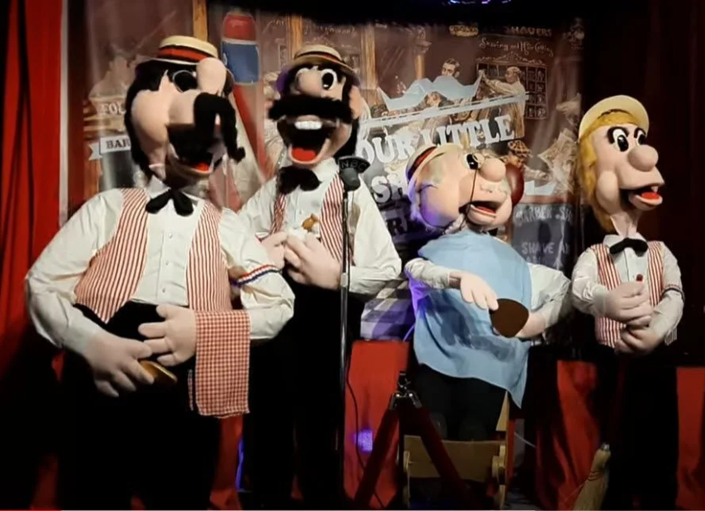 Four puppets performing on stage.