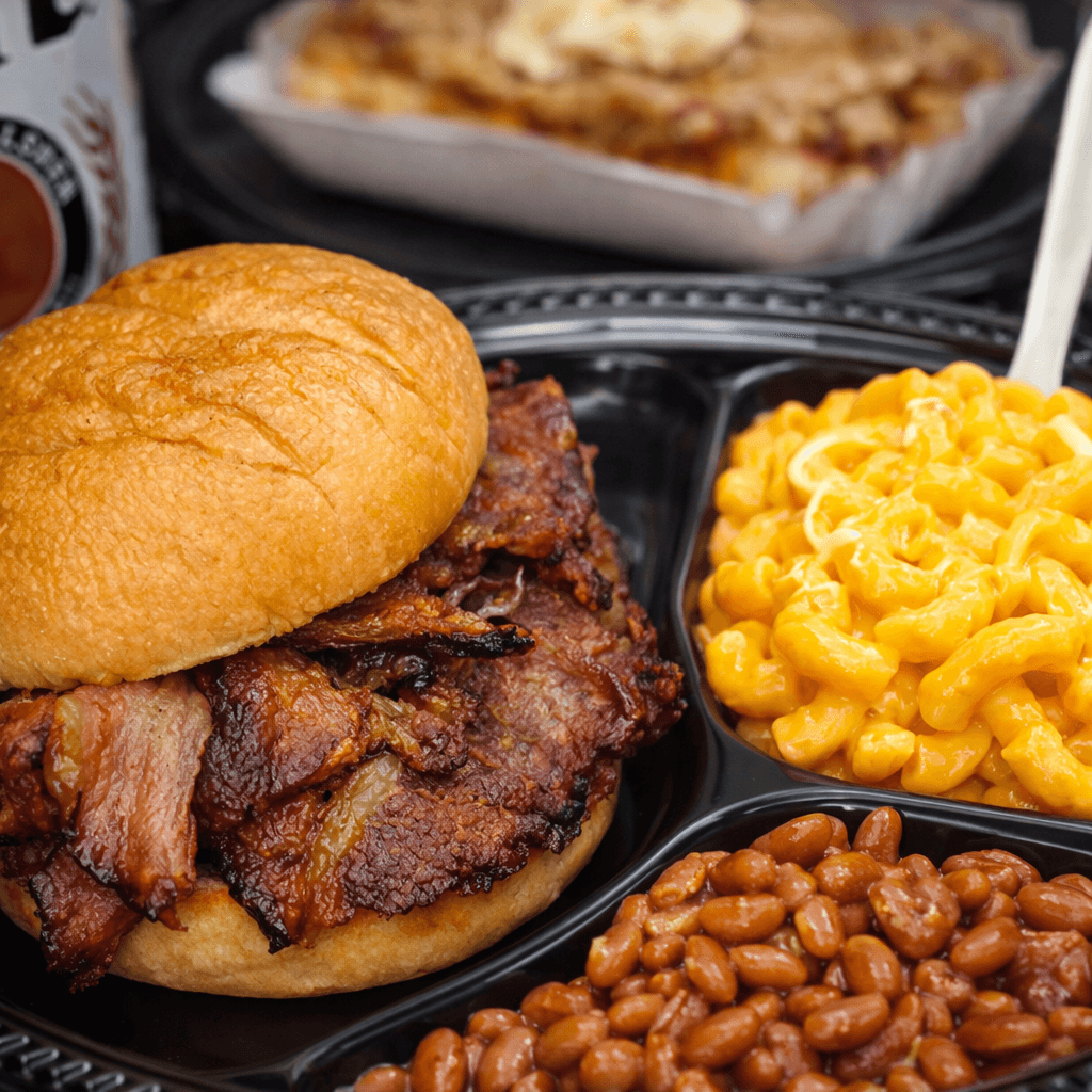 Barbecue sandwich with sides of macaroni.