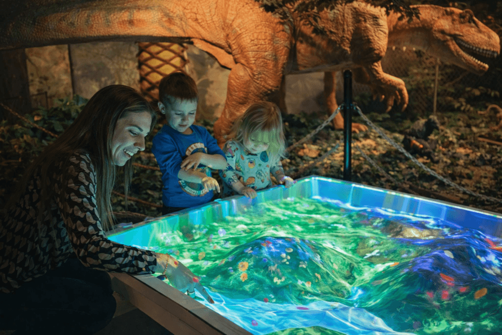 Children interacting with a colorful sandbox.