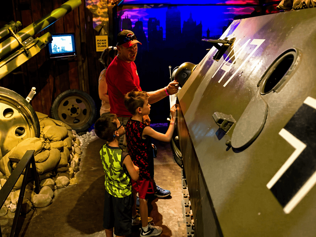 Children exploring military vehicle exhibit