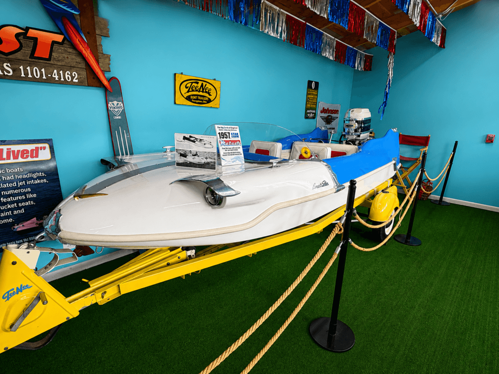 Vintage boat displayed indoors with decorations.