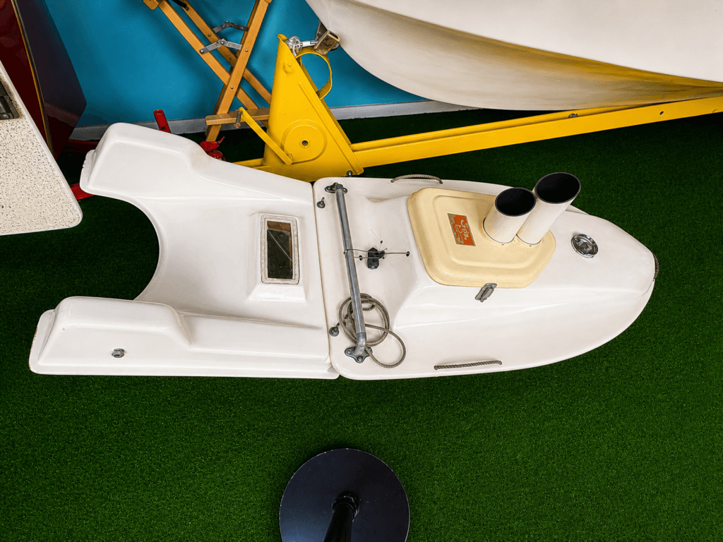 Small white boat on green surface