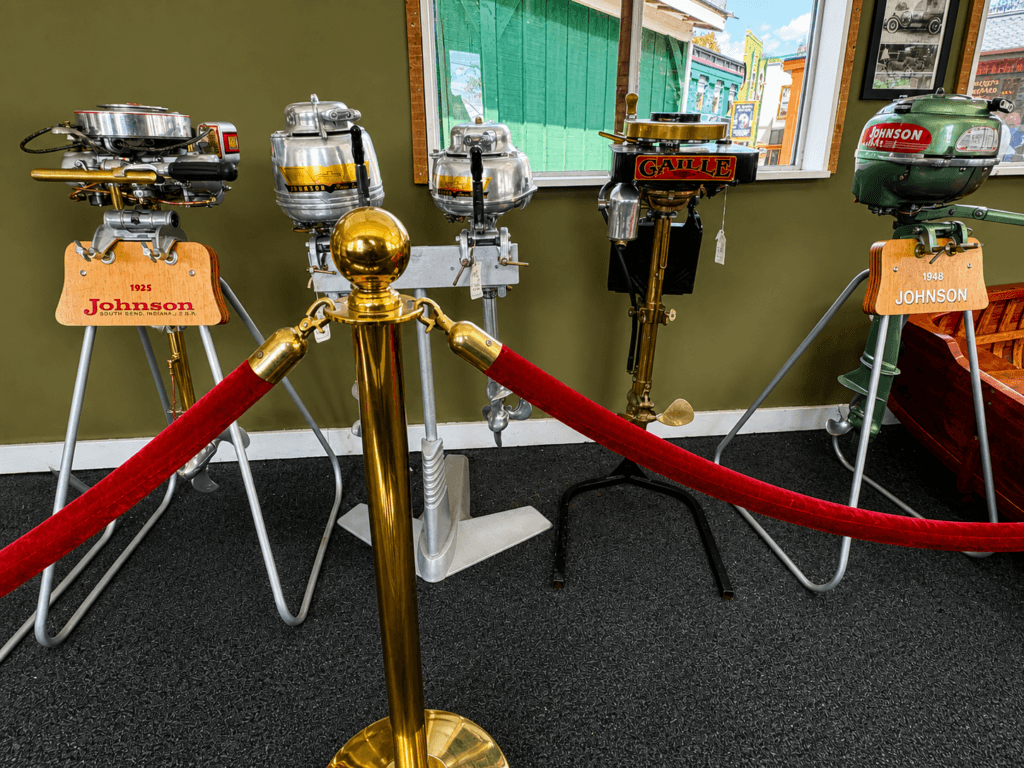 Three vintage outboard motors displayed.