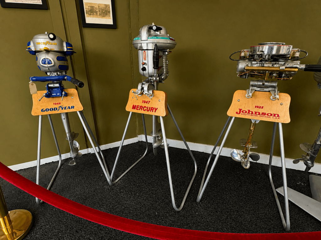 Three vintage outboard motors displayed.
