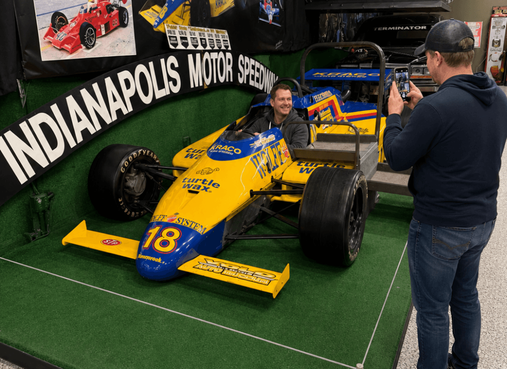Man photographing a race car display.