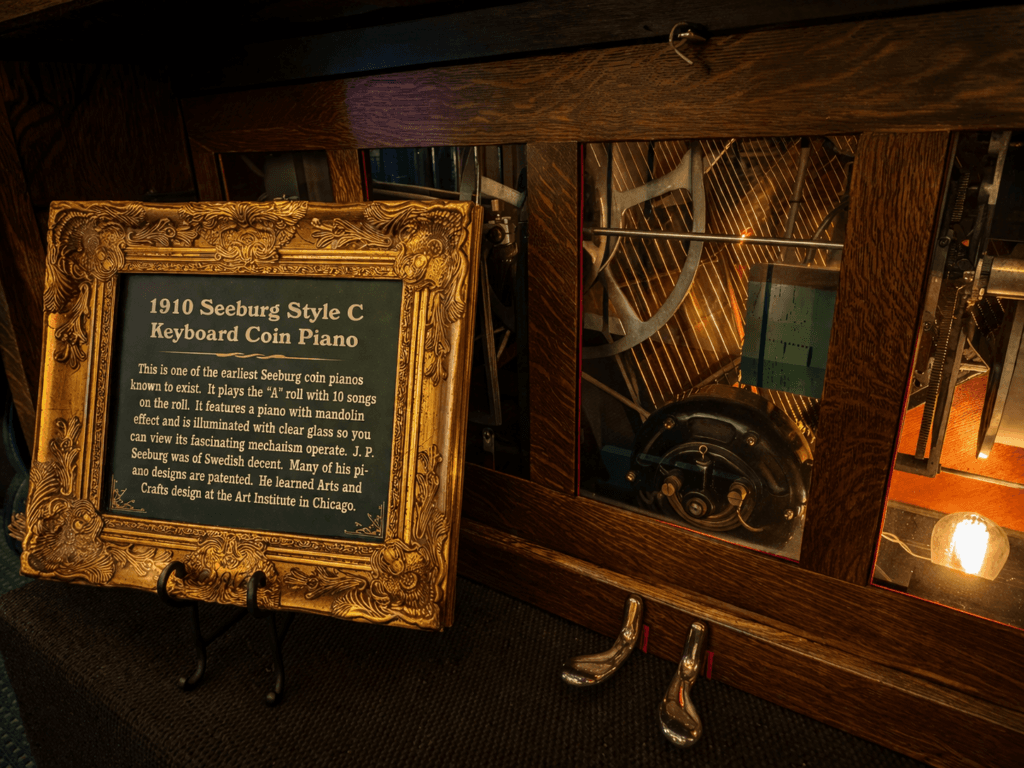 Antique coin piano with informational plaque