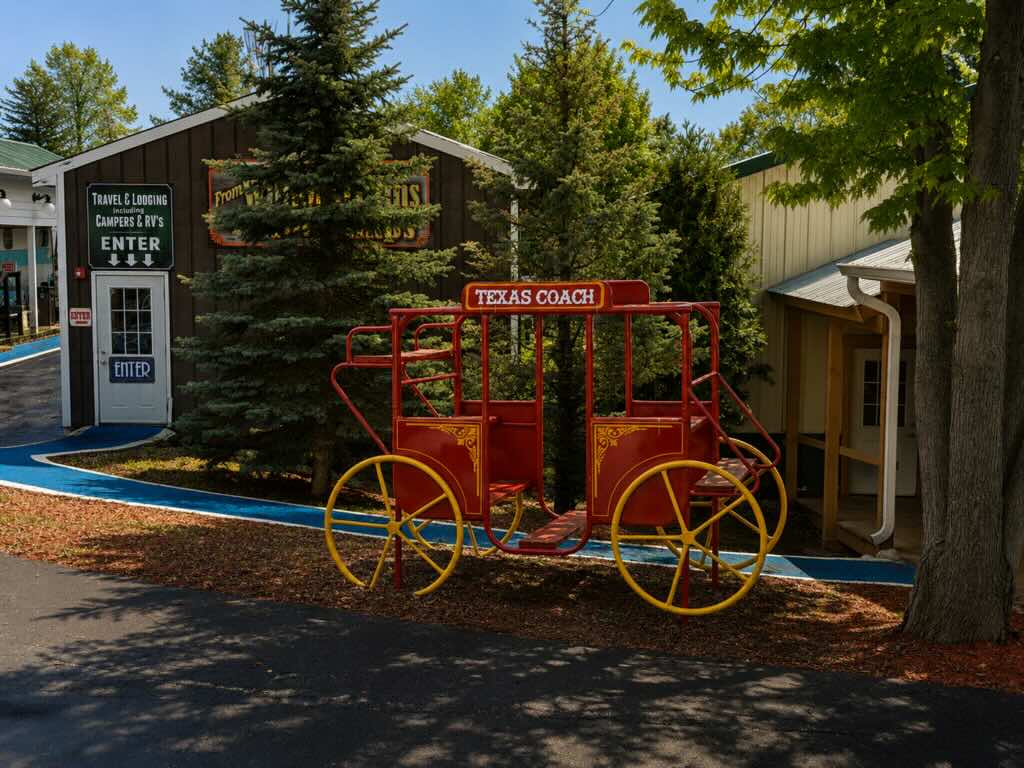 Red wagon near buildings and trees.