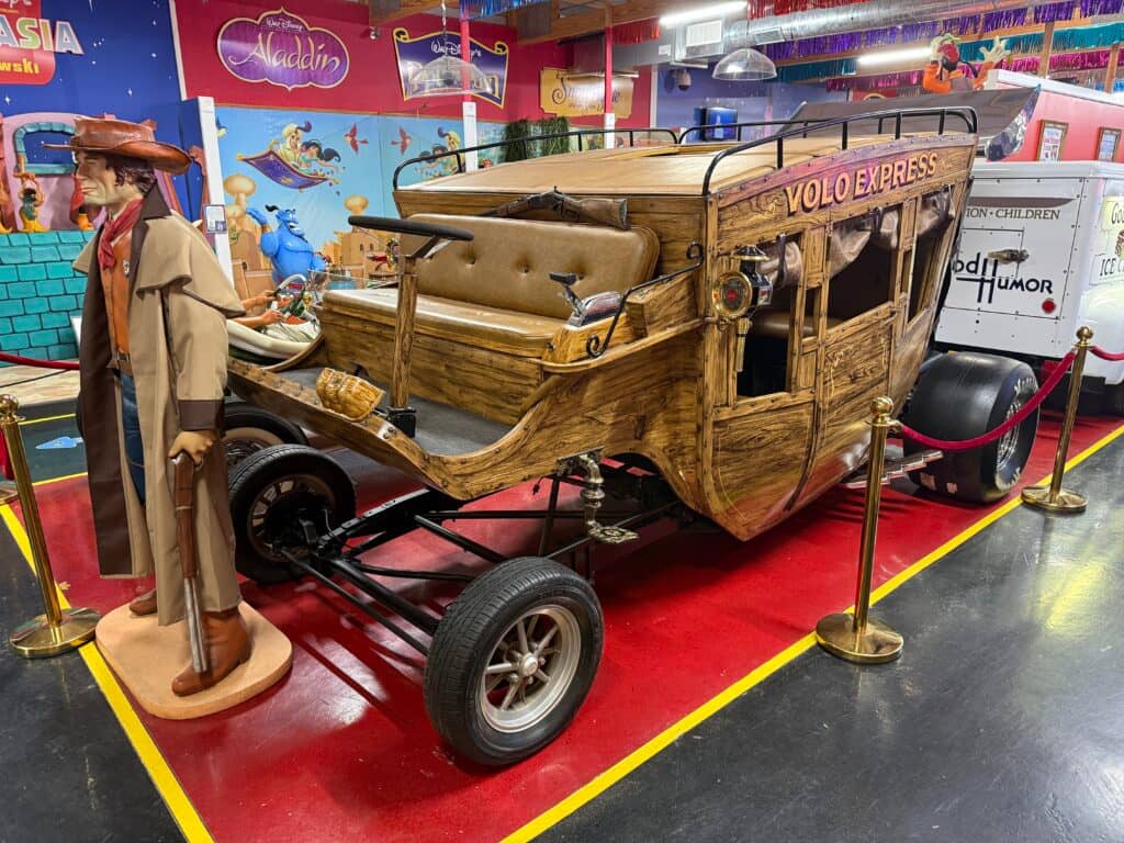 Wooden car with cowboy figure nearby